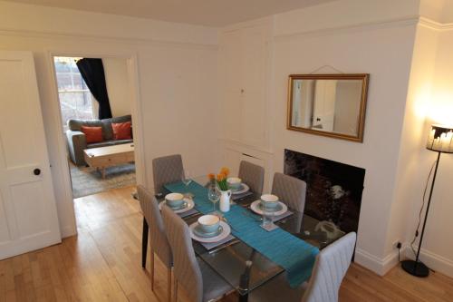 a dining room with a table and chairs and a fireplace at Alma House by 360Stays - Private Garden, Free Parking, Close to Oxford City Centre with Parking in Oxford