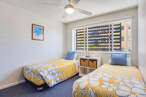 馬盧奇多的住宿－珊瑚海公寓，一间卧室设有两张床和窗户。