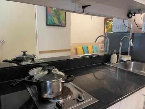 a kitchen with two pots and pans on a stove at Premiere Haven MOA Staycation in Manila