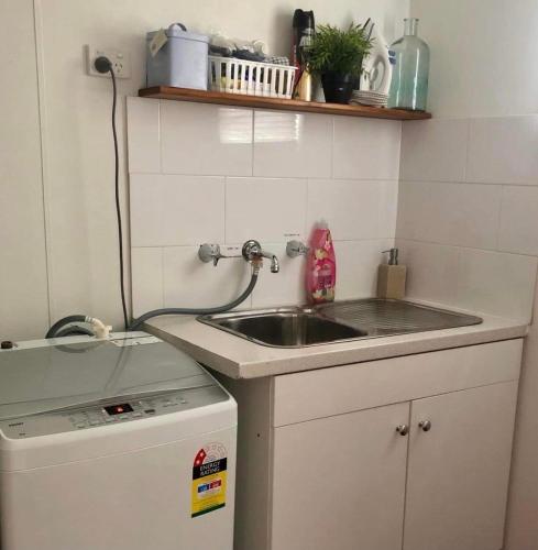 a small kitchen with a sink and a dishwasher at The Husky House or Little Husky Studio Suite in Huskisson