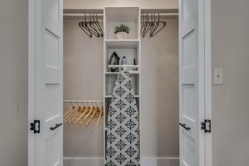 a walk in closet with white cabinets and a mirror at The Blue Diamond Retreat in Brenham