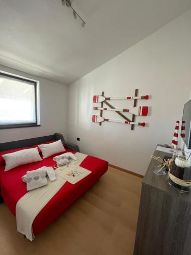 a bedroom with a bed with red sheets and white pillows at Residence4a-Appartamento Rosso in Ravni
