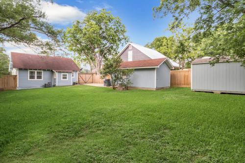a yard with a white house and a fence at The Blue Diamond Retreat in Brenham