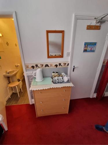 a room with a table with a mirror and a door at The Ryecroft in Great Yarmouth