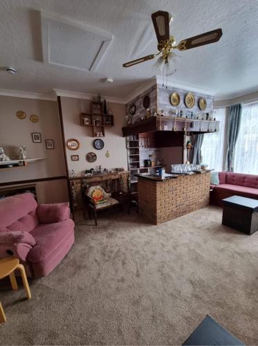 a living room with a couch and a ceiling fan at The Ryecroft in Great Yarmouth