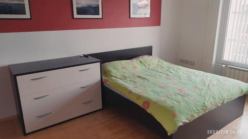 a small bedroom with a bed and a dresser at city center park view appartment in Maribor