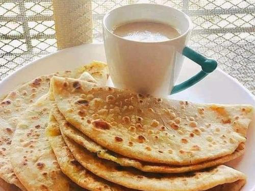 une assiette avec une pile de tortillas et une tasse de café dans l'établissement BABAR HOTEL And RESTAURANT, à Swat