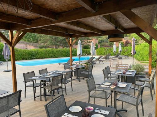 een restaurant met tafels en stoelen naast een zwembad bij Résidence Les Cigales in Porto-Vecchio