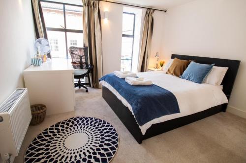 a bedroom with a bed and a desk and a window at The New52 Oxford by 360Stays - Bespoke 2 Bed Luxury Apartment in the Heart of Oxford City Center with Parking in Oxford