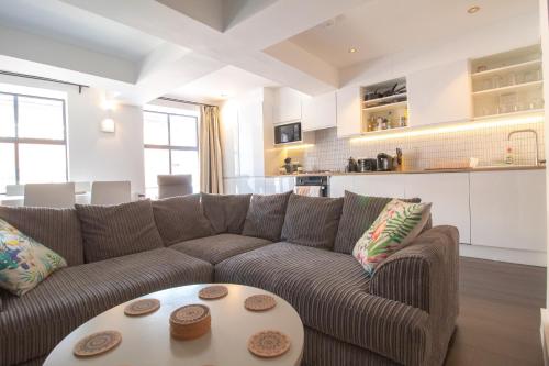 a living room with a brown couch and a table at The New52 Oxford by 360Stays - Bespoke 2 Bed Luxury Apartment in the Heart of Oxford City Center with Parking in Oxford