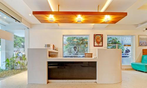 a living room with a reception desk with a blue couch at Treebo Trend Vinayak Inn, Near Railway Station in Coimbatore