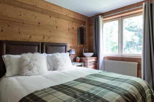 sypialnia z łóżkiem z drewnianą ścianą w obiekcie Chalet Pres des Cimes ski-in ski-out w mieście Les Houches