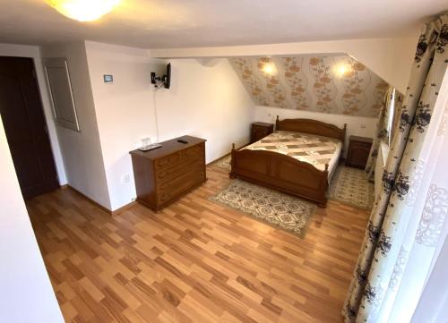 - une petite chambre avec un lit et du parquet dans l'établissement Casa Barkov, à Barcani
