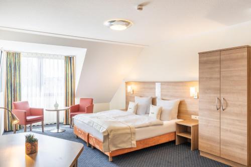 acora Bochum Living the City - Apartments في بوخوم: غرفة فندقية بسرير وطاولة وكراسي
