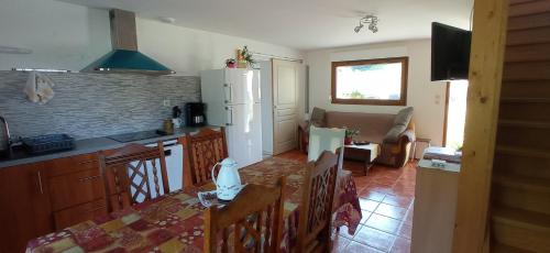 a kitchen with a table and a white refrigerator at Haut pré de ces Dames in Cornimont