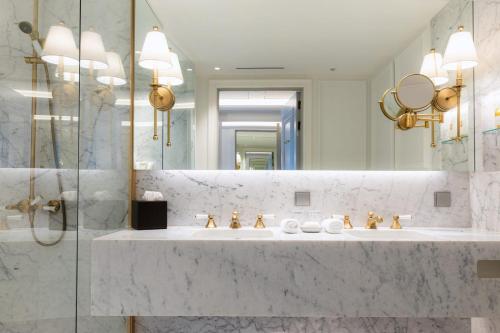 a bathroom with three sinks and a mirror at Britannia Hotel in Trondheim