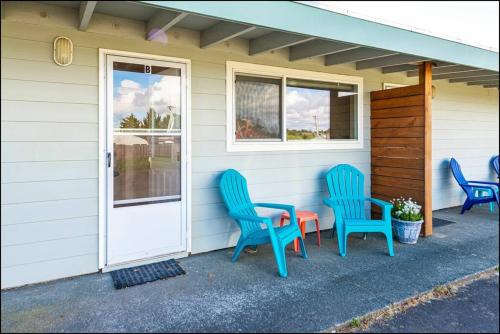 three blue chairs and a table on the side of a house at Sea Star Condo in Ocean Shores