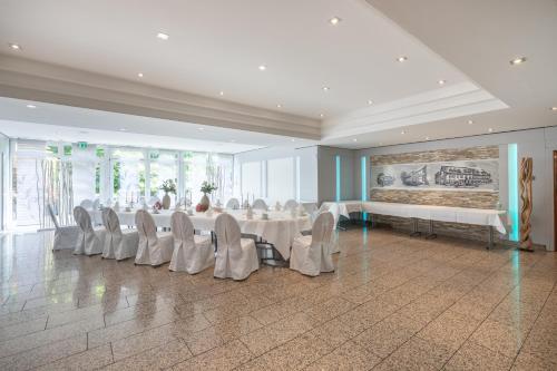 a large banquet hall with white tables and chairs at Hotel Elisenhof Mönchengladbach in Mönchengladbach