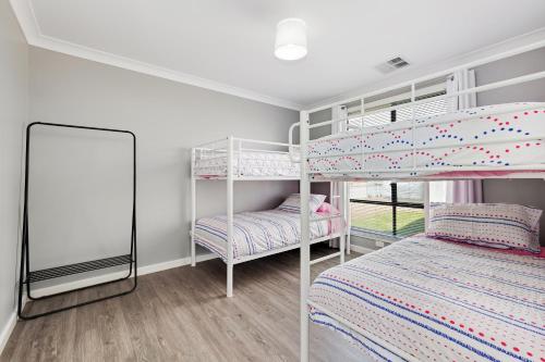 a bedroom with two bunk beds and a mirror at 33 Jefferson Court, Wellington East in Wellington East