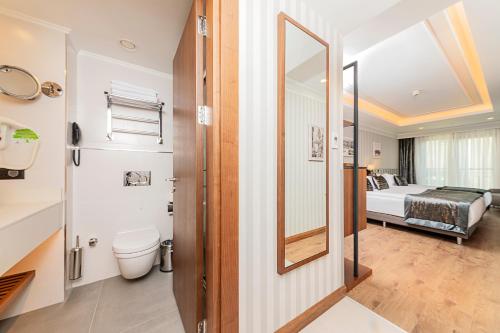 a bathroom with a toilet and a bed in a room at Mukarnas Pera Hotel in Istanbul