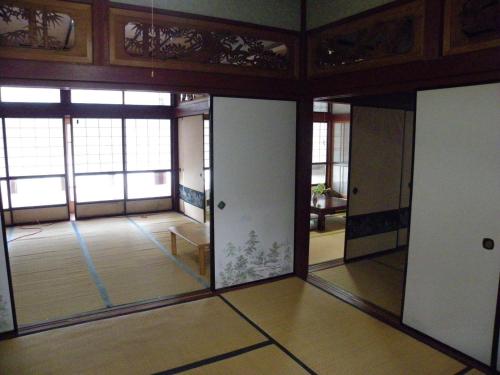 an empty room with glass doors and windows at Noukaminsyuku Zakuro no Yado / Vacation STAY 15439 in Sabae