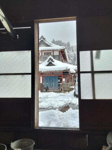 a window view of a house in the snow at Noukaminsyuku Zakuro no Yado / Vacation STAY 15439 in Sabae