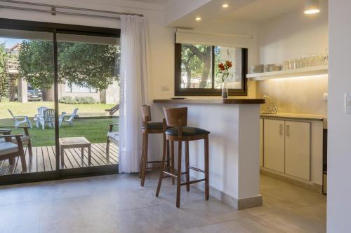 a kitchen with a bar with a view of a yard at Ville Saint Germain Apart Hotel & Spa in Carilo