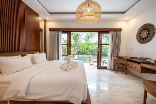 a bedroom with a bed and a desk and a window at Tamantara in Ubud