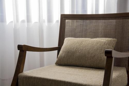 a pillow sitting on a chair in front of a window at Ville Saint Germain Apart Hotel & Spa in Carilo
