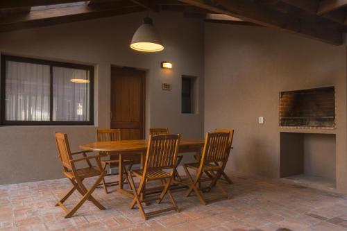 a dining room with a wooden table and chairs at Ville Saint Germain Apart Hotel & Spa in Carilo