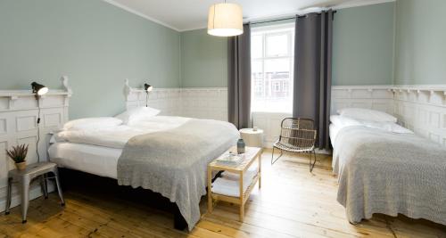 a bedroom with two beds and a table at Old Charm Reykjavik Apartments in Reykjavík