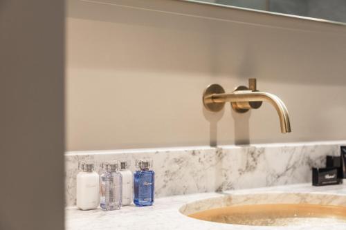 a bathroom sink with a faucet and two bottles of soap at Hotel 717 in Amsterdam