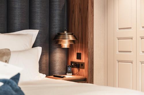 a bedroom with a bed with white sheets and a lamp at Hotel 717 in Amsterdam