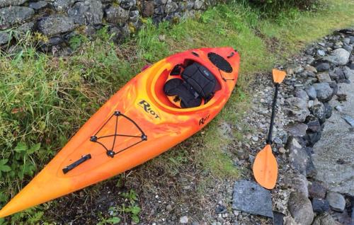 an orange kayak sitting on the grass with a paddle at 3 Bedroom Amazing Home In Skjold in Skjold