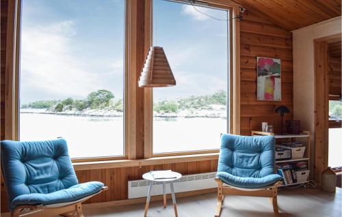 two blue chairs in a room with a large window at 3 Bedroom Amazing Home In Skjold in Skjold