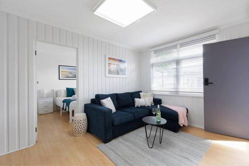 a living room with a blue couch and a table at Belle Retreat by the River & Ocean Pet Friendly in Ocean Grove