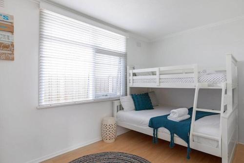 a bedroom with two bunk beds and a window at Belle Retreat by the River & Ocean Pet Friendly in Ocean Grove