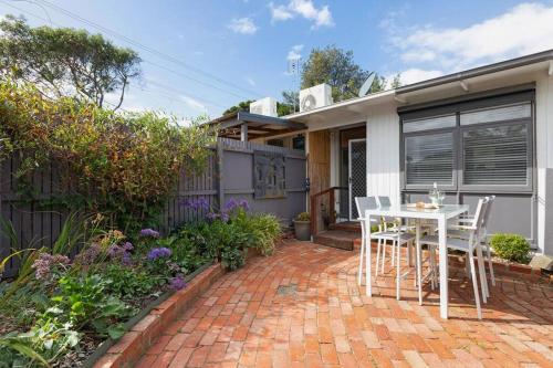 a patio with a table and chairs in front of a house at Belle Retreat by the River & Ocean Pet Friendly in Ocean Grove