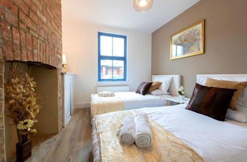 a bedroom with two beds and a fireplace at TempleTwenty5 by 360 Stays - Highly Rated Oxford Home with Parking in Oxford