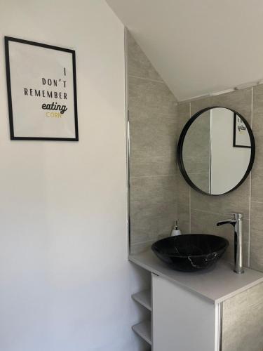 ein Bad mit einem schwarzen Waschbecken und einem Spiegel in der Unterkunft Stylish and Modern 3 bed Apartment with FREE PARKING, in Newcastle upon Tyne