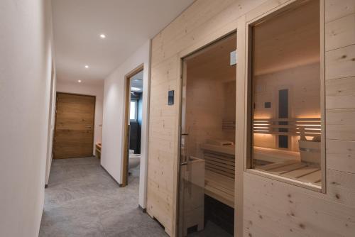 baño con paredes de madera y ducha a ras de suelo en Mesnerhof Chalet en Bressanone