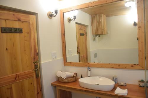 a bathroom with a sink and a mirror at Kudrat - A Boutique Homestay- Tirthan Valley in Banjār