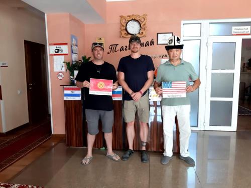 three men standing in a room holding up certificates at Tagaytay Karakol Hotel in Karakol