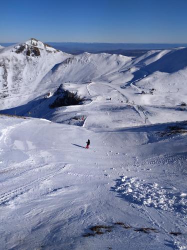 a person is skiing down a snow covered mountain at Les marmottes du Sancy in Le Mont-Dore