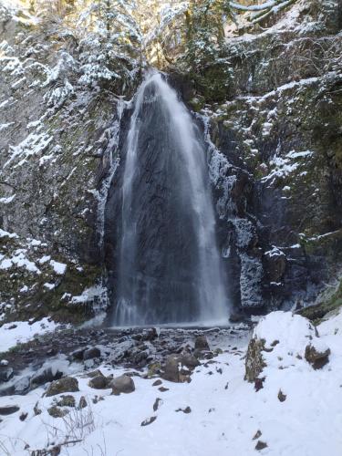 a waterfall on the side of a mountain in the snow at Les marmottes du Sancy in Le Mont-Dore