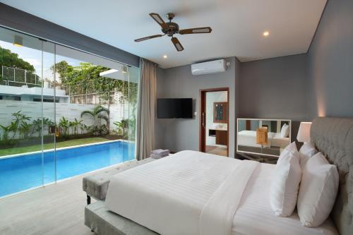 a bedroom with a large bed and a swimming pool at The Daha Luxury Villas in Seminyak