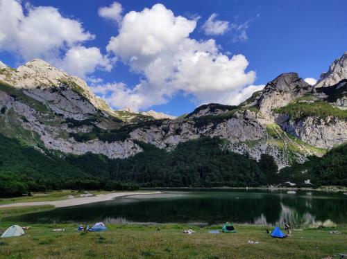 a group of tents next to a mountain lake at Apartmani Košuta in Tjentište