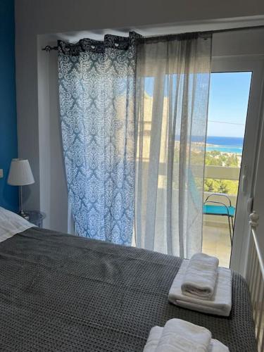 una camera da letto con un letto e una grande finestra di Karakonero view apartment a Città di Rodi