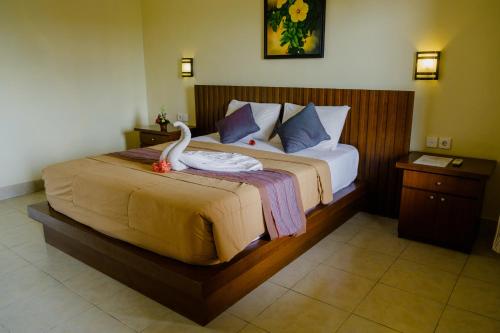 Un dormitorio con una cama con un cisne. en Desak Putu Putra Home Stay, en Ubud