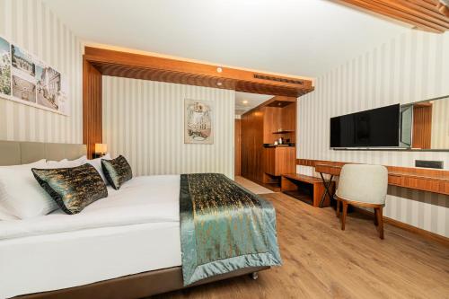a bedroom with a bed and a desk and a television at Mukarnas Pera Hotel in Istanbul